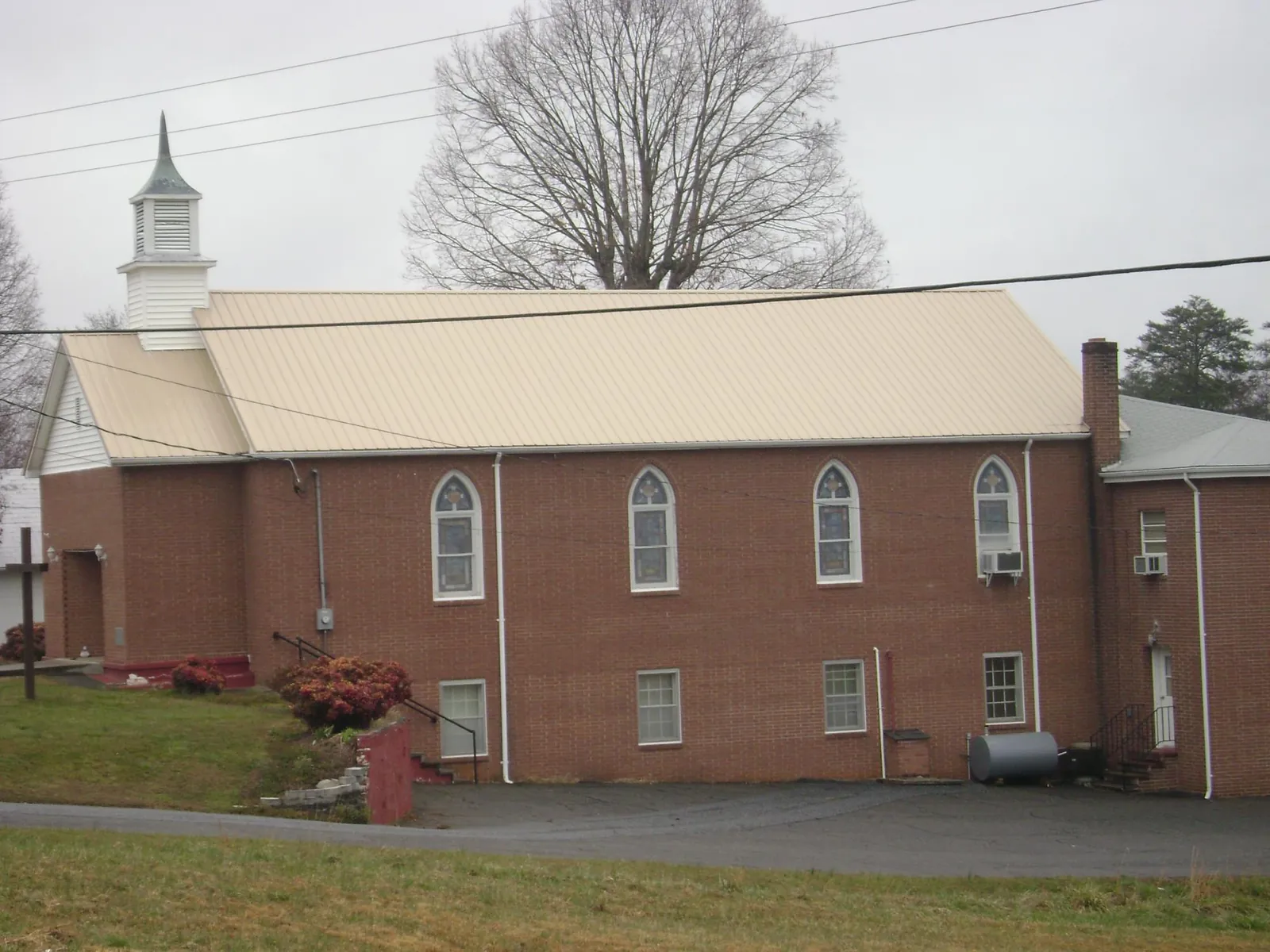 New tan metal roof on a brick church with a white steeple in Parris Island